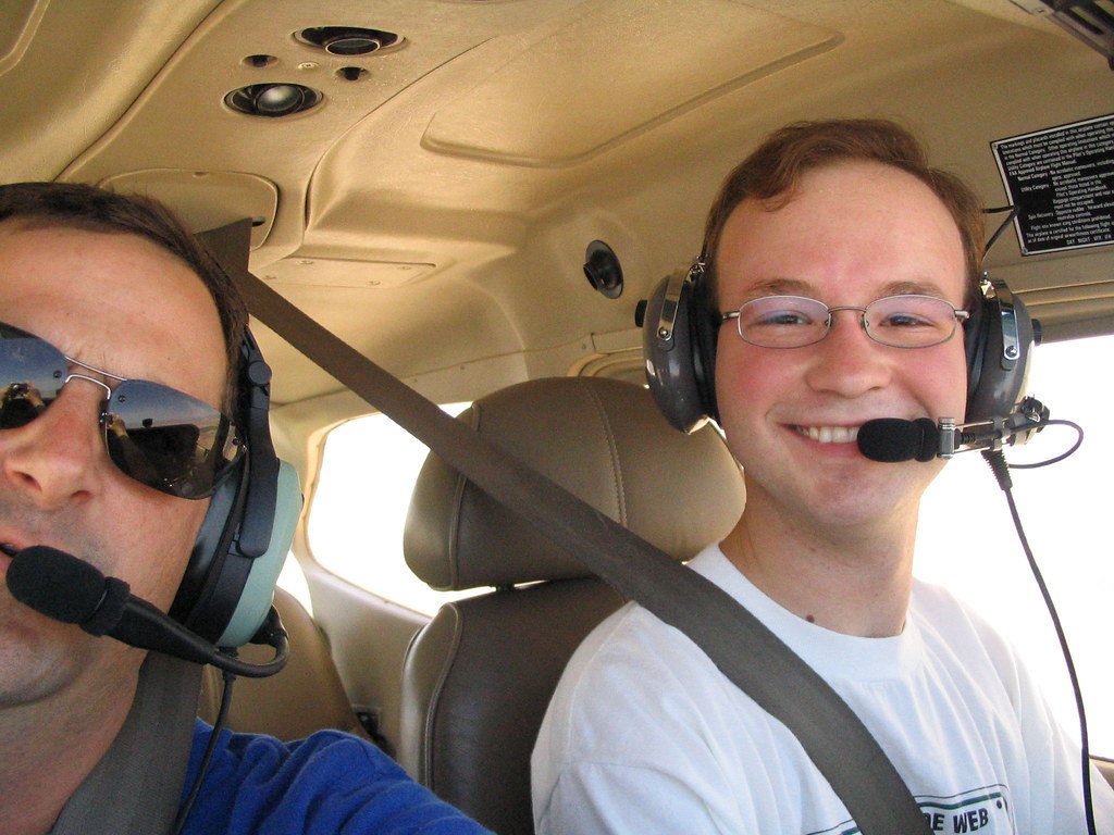 Happy young driver in a car with an instructor