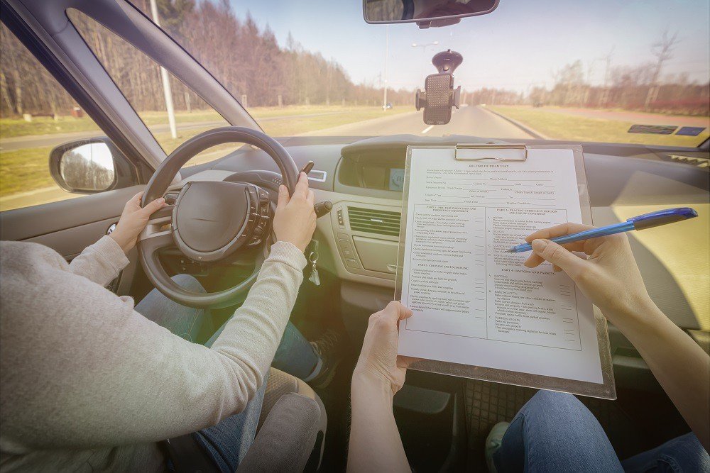 Driving instructor teaching a student in a car